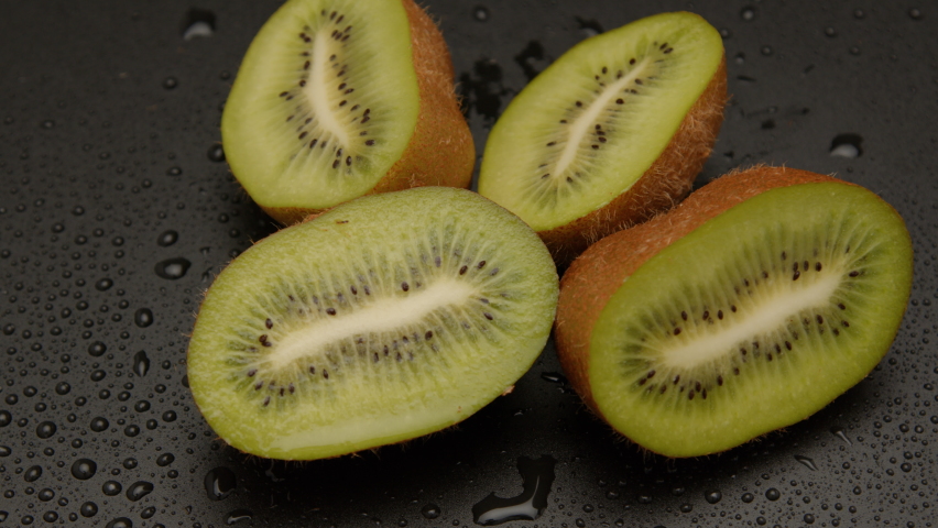 Rotating kiwi fruits slices. Super Slow Motion Shot. heap sliced and whole kiwi fruit close up. Kiwi Fruit Slices Rotating