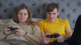 Man and woman playing joysticks and talking