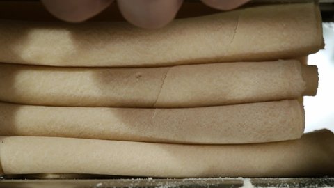 Fresh dough coming out of pasta machine, close-up. Traditional italian homemade pasta being made on machine for cutting dough. 