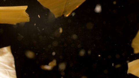 Super slow motion broken glass shards flying through the air isolated on black background. Filmed on high speed cinema camera, 1000 fps