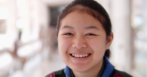 Slow motion scene of a young Asian female student girl is smiling and laughing happily and shy.