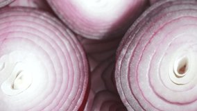 Sliced red onion rings rotating in 4K. Closeup top view of healthy food background with vegetable of rich vitamin