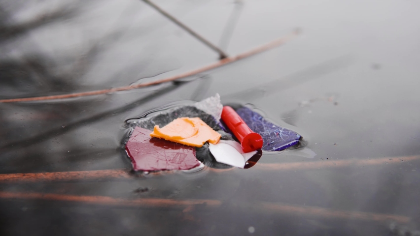 Residue of plastics in a river stream. Sea shore polluted with micro-plastic bits gathered together. Island of plastic in the ocean