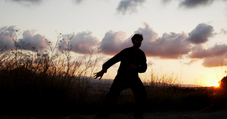 Man practicing martial arts during sunrise. Chi kung, Kungfu