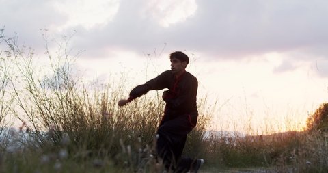 Man practicing martial arts during sunrise. Chi kung, Kungfu
