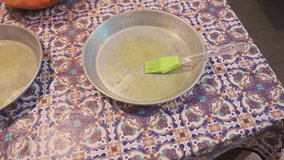 Homemade pizza preparation. Panoramic footage on the table where pans have been sprinkled with oil, one salad bowl is filled with a mix of vegetables and mozzarella, the other has slices of aubergine.