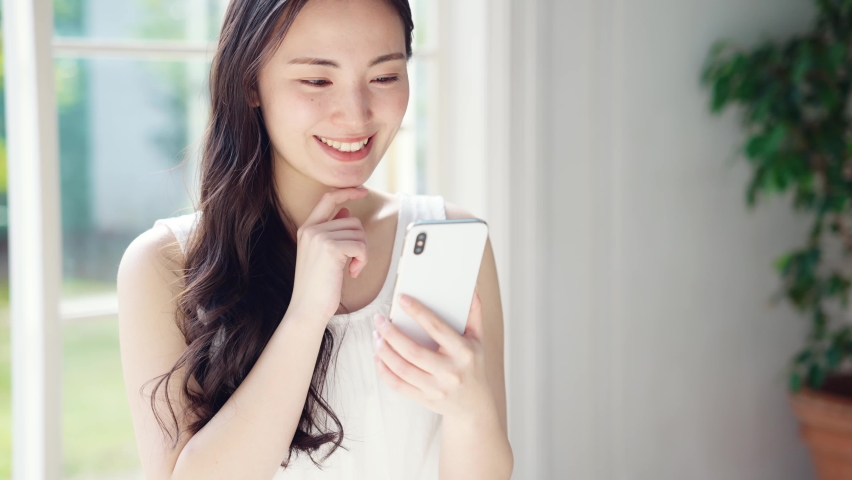 Young asian woman using a smart phone. Mobile communication. Royalty-Free Stock Footage #1069455616