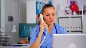 Medical practitioner answering phone calls and scheduling appointments in hospital. Healthcare physician in medicine uniform, receptionist doctor assistant helping with telehealth communication - Powered by Shutterstock - Get 15% off with code: PIKWIZARD15