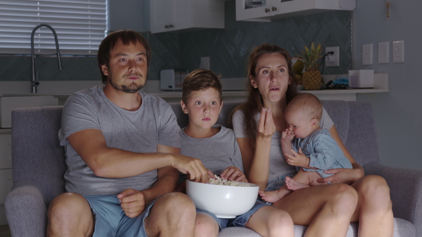 Excited family cheering in front of tv. big happy family watching sport match on tv feeling excited and thrilled.
