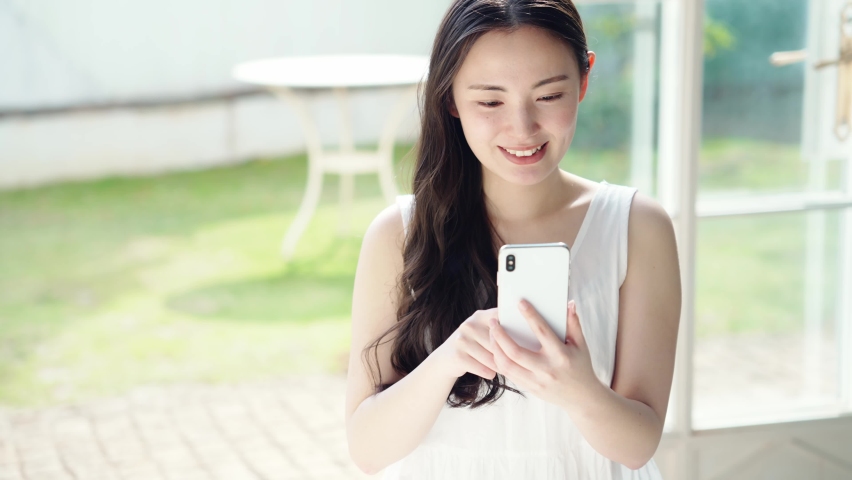 Young asian woman using a smart phone. Mobile communication. Royalty-Free Stock Footage #1069458169