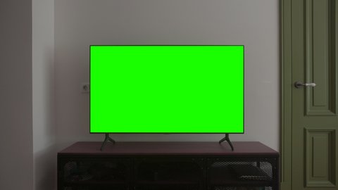 TV mockup screen. LSD smart TV screen with a blank green background in the living room before watching movies and videos on the Internet in 4K