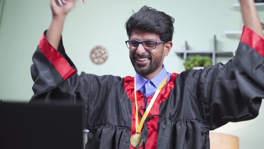 Concept of virtual graduation due to coronavirus covid-19 pandemic - graduation student throwing his hat or cap during video call on laptop after online celebration.