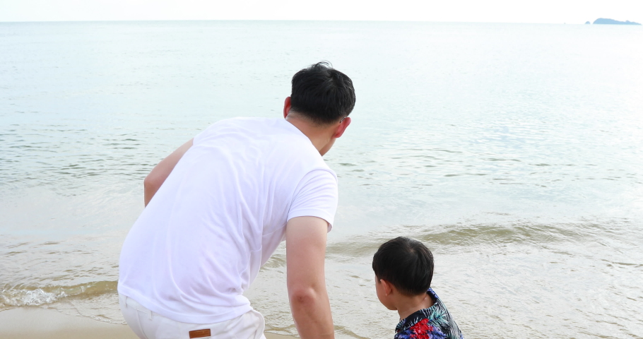Father and Son Holding Hands Walking and playing Together on the Beach. father