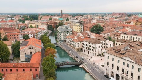 AERIAL: Fly over Treviso, Italy in a summer day. Drone shot above the canals and bridges.