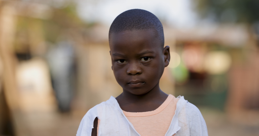 Poverty.Inequality.Portrait of a poor Black African boy looking at camera with a sad expression in a slum surrounding Royalty-Free Stock Footage #1069477144