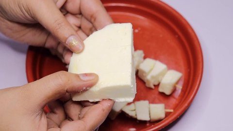 Woman Hands Cutting fresh Paneer  on a Plate