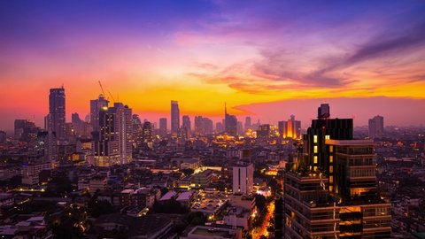 day to night time lapse of modern skyline office, condo, and apartment in downtown business zone in Bangkok Capital city of Thailand, with traffic transportation before sunset and city light