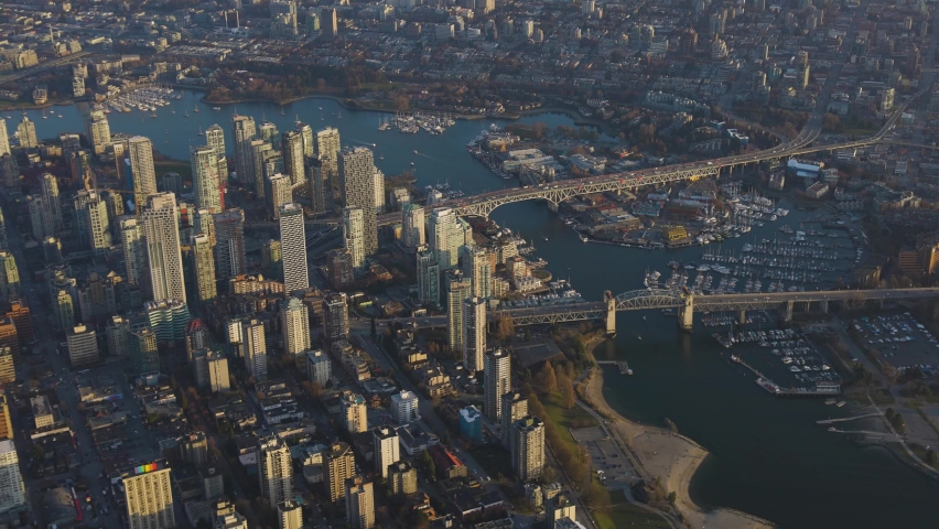 Aerial View of modern Downtown City viewed from an airplane. Picture taken in Vancouver, British Columbia, Canada, during a sunny sunset.