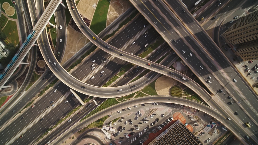 Aerial view of vehicles driving along Sheikh Zayed road with a complex and busy intersection right in Dubai downtown, United Arab Emirates.