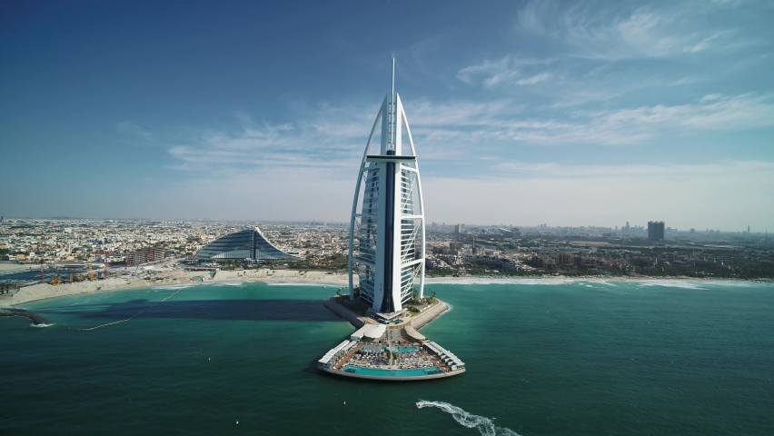 Dubai, United Arab Emirates - 16 March 2021: Aerial view of a person sailing with a speedboat near the Burj Al Arab luxury hotel, Dubai, United Arab Emirates.