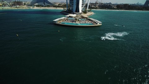 Dubai, United Arab Emirates - 16 March 2021: Aerial view of a person sailing with a speedboat near the Burj Al Arab luxury hotel, Dubai, United Arab Emirates.