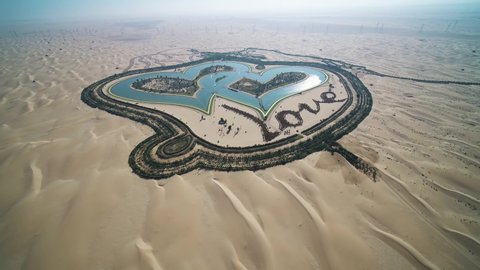 Aerial view of heart shaped artificial lake with Love written in the sand of Dubai desert, Dubai United Arab Emirates.