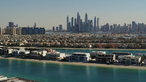 Aerial view of Dubai residential district with luxury villas at The Palm Jumeirah district with skyline in background, Dubai, United Arab Emirates.