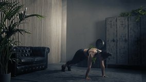 Sporty and beautiful brunette woman doing shoulder tap push ups in sportswear at home. Slow motion