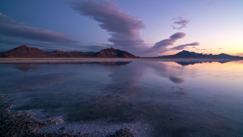 Time lapse of colorful sunrise reflecting over the Great Salt Lake as water covers the Bonneville Salt Flats in Utah.