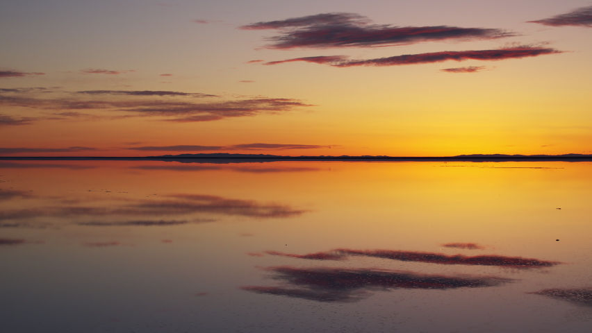 Sunrise reflection over the Great Salt Lake as water shimmers covering the Bonneville Salt Flats in Utah.