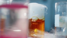 Video closeup details in the scientist laboratory experiment of a chemical substance reaction in the flask