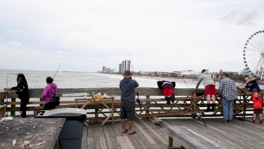 MYRTLE BEACH, SC - APRIL 2018: Buildings and city beach view from the wooden pier. Myrtle Beach attracts 3 million people annually.