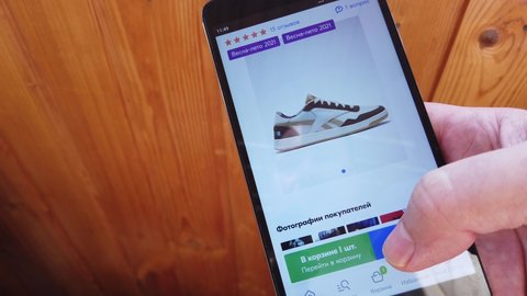 Smart phone online shopping Ozon. Man orders shoes home in an online store using a smartphone. Moscow, Russia March 24 2021