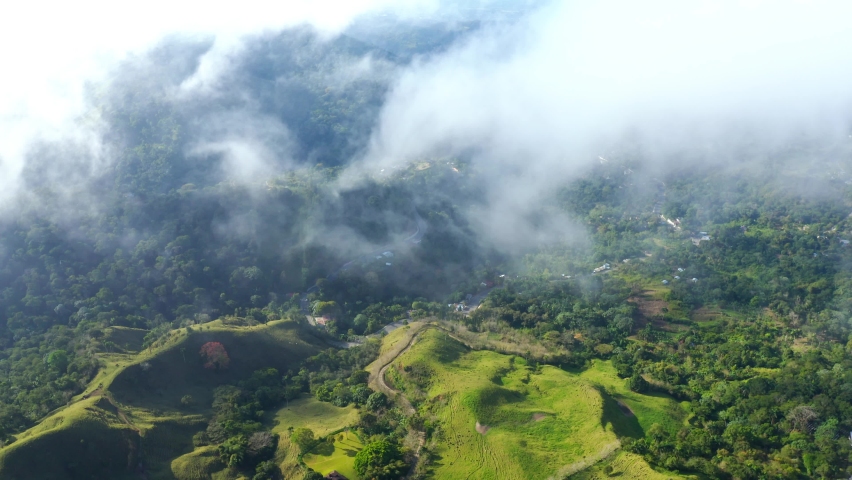 Air travel through clouds to mountain peaks 4k stock video background. Aerial view of the nature of the Dominican Republic from a bird