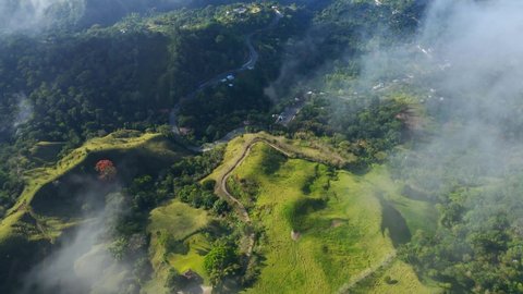 Air travel through clouds to mountain peaks 4k stock video background. Aerial view of the nature of the Dominican Republic from a bird's eye view. Mountain summer morning landscape.