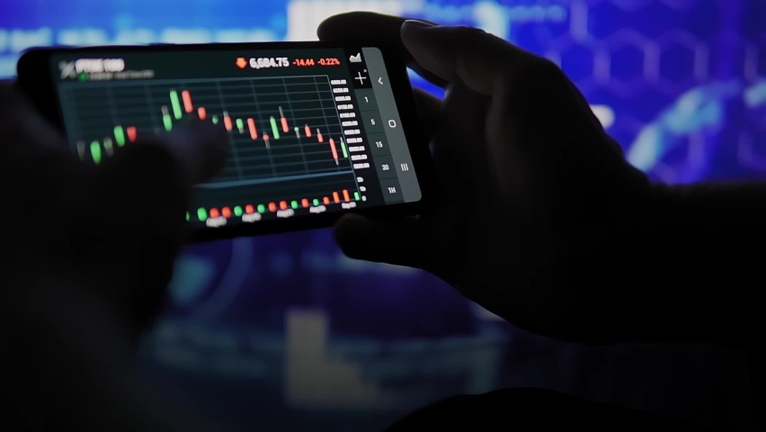 Man is watching financial graph on smartphone screen. Animated background. Financial market and trading concept | Shutterstock HD Video #1069532782