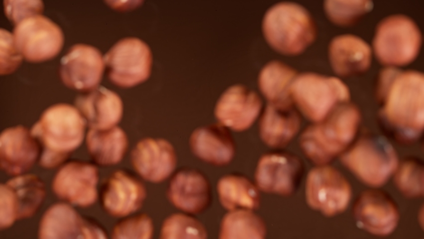 Super Slow Motion Shot of Hazelnuts Falling into Melted Chocolate at 1000 fps. Royalty-Free Stock Footage #1069537315
