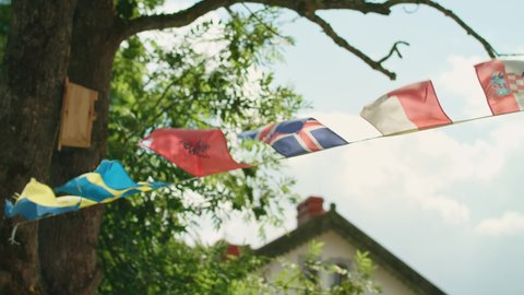 European flags waving in the wind, sky and sun Background, Slow Motion. Spring flags in village. Spring mood. Beautiful nature. Sunset. Sunlight flags. Sweden flag, Poland Flag 4K UHD Slow-Motion 