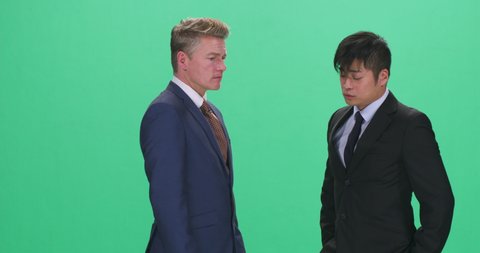 Man in suit yelling and strangling colleague, green screen
