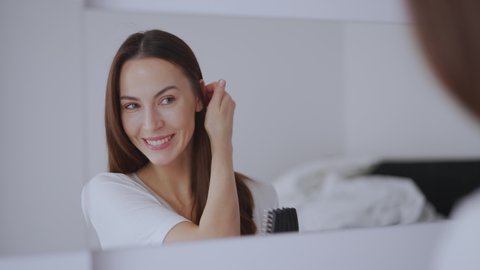 Positive female combing hair in morning