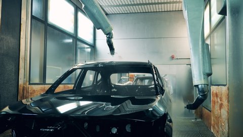 Automotive painter robots painting a car body on a car assembly line