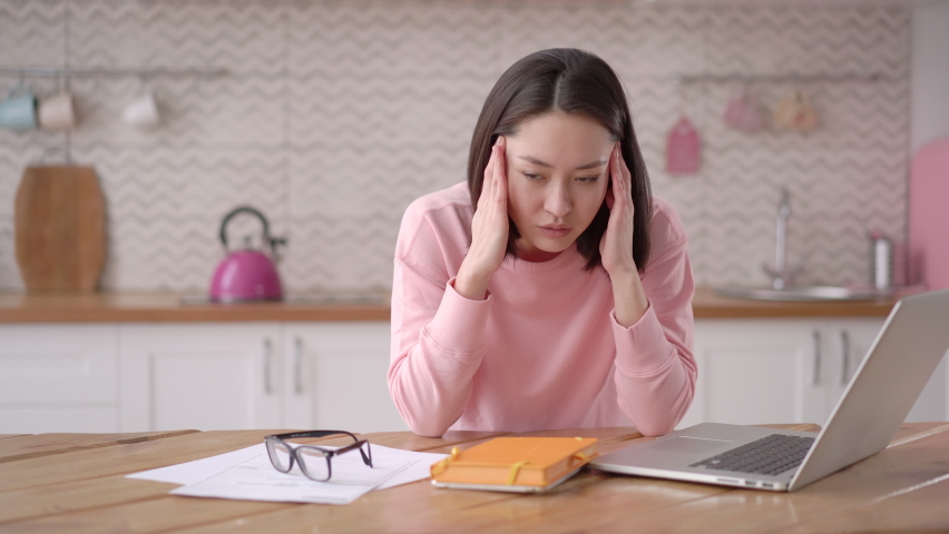 Stressed exhausted mixed race business woman working from home take off glasses feel eye strain fatigued from laptop computer. Tired overloaded with work asian freelancer suffer from headache pain Royalty-Free Stock Footage #1069548559