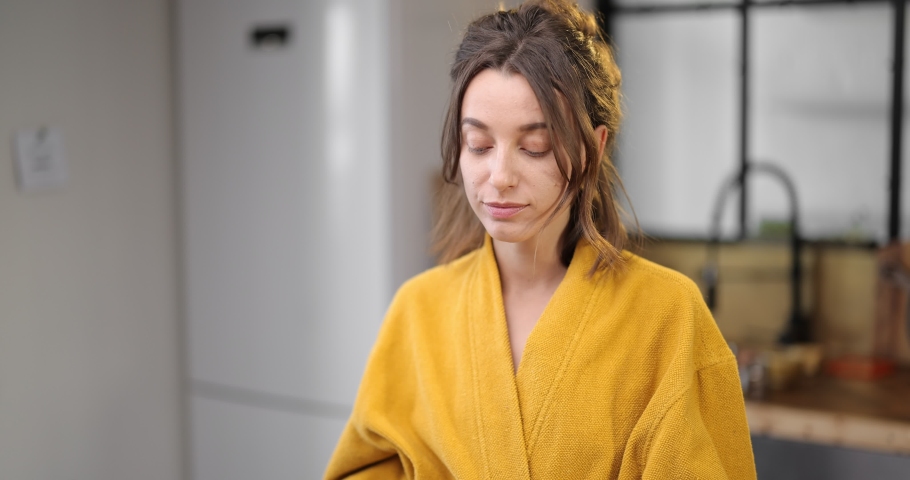 Happy woman with avocado in the morning at home