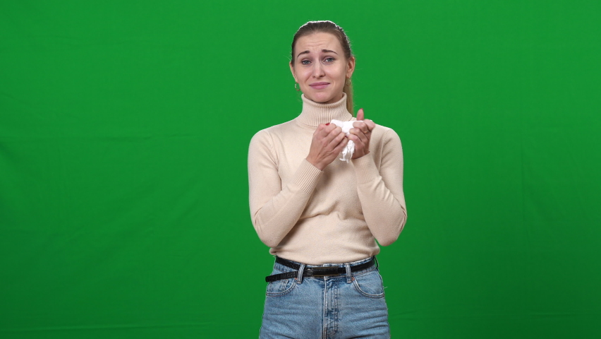 Young emotional Caucasian woman crying wiping tears with tissue. Portrait of young lady on green screen expressing emotions. Chromakey. | Shutterstock HD Video #1069554988