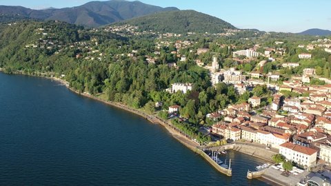 View from drone of summer Luino cityscape and Lake Maggiore, province of Varese, Lombardy, northern Italy. High quality 4k footage