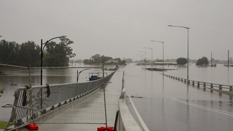 pan of flood water from the hawkesbury river flowing over the new windsor bridge at windsor in nsw, australia
