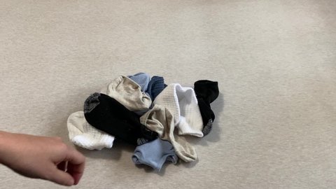 Person folding neutral-colored socks after doing laundry. Clean socks. Organizing concept. 