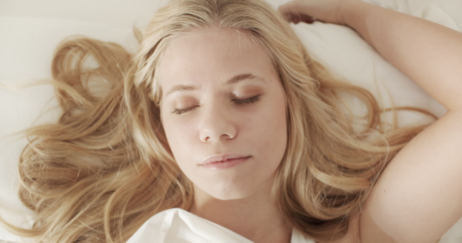 Closeup portrait shot of a gorgeous young model lying down in bed as she wakes up from a long sleep with a good mood