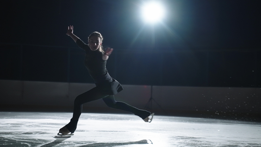 young female figure skater is training Biellmann spin on ice rink, athletic girl is dresses black sportswear, exercising new elements before competition, professional sport Royalty-Free Stock Footage #1069567513