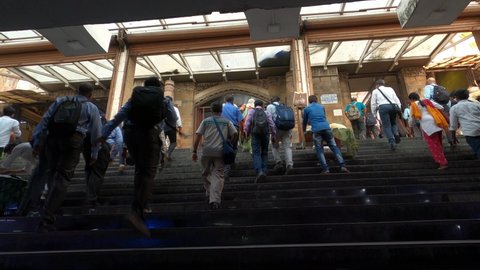 Mumbai, Maharashtra, India - March 15, 2021 - 4K Still Timelapse of a big crowd of people walking commuting from an underground subway to Chhatrapati Shivaji Terminus CST Railway Train Station, Fort.